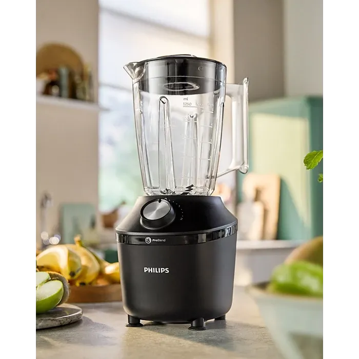 Philips blender fra 3000-serien i sort design, plassert på et kjøkkenbord med frisk frukt rundt.