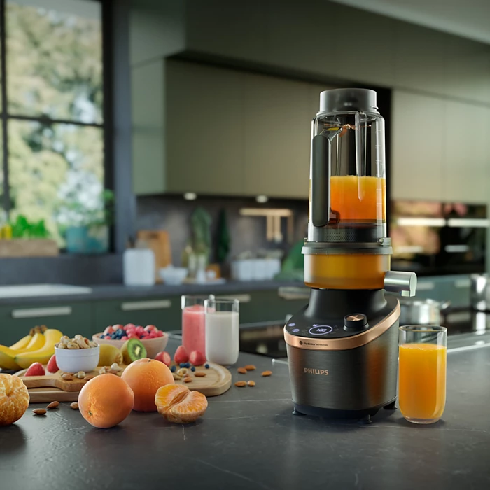 Philips Flip & Juice™ Blender på kjøkkenbenken med friske frukter og juice.