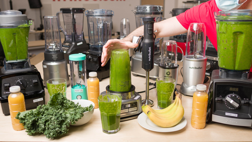 Flere blendere, inkludert Vitamix, Nutribullet og Ninja, blendOn sammenlignes i en smoothie-test med ferske grønnsaker og frukt på en kjøkkenbenk i lokalet til blender best i test